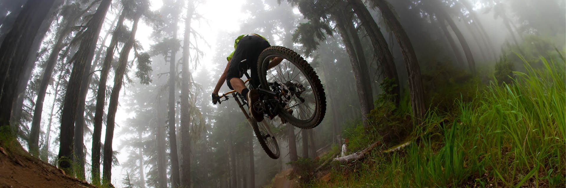 Mountain bike mid-air on downhill forest track