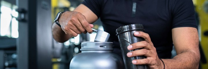 Man making protein shake in the gym