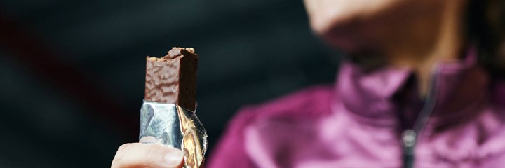 Woman holding unwrapped protein bar
