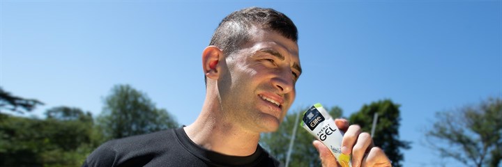 Jonny May taking an Elite Energy gel with blue sky in the background