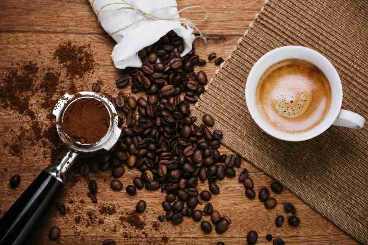 overhead shot of coffee in a cup, coffee beans and ground coffee