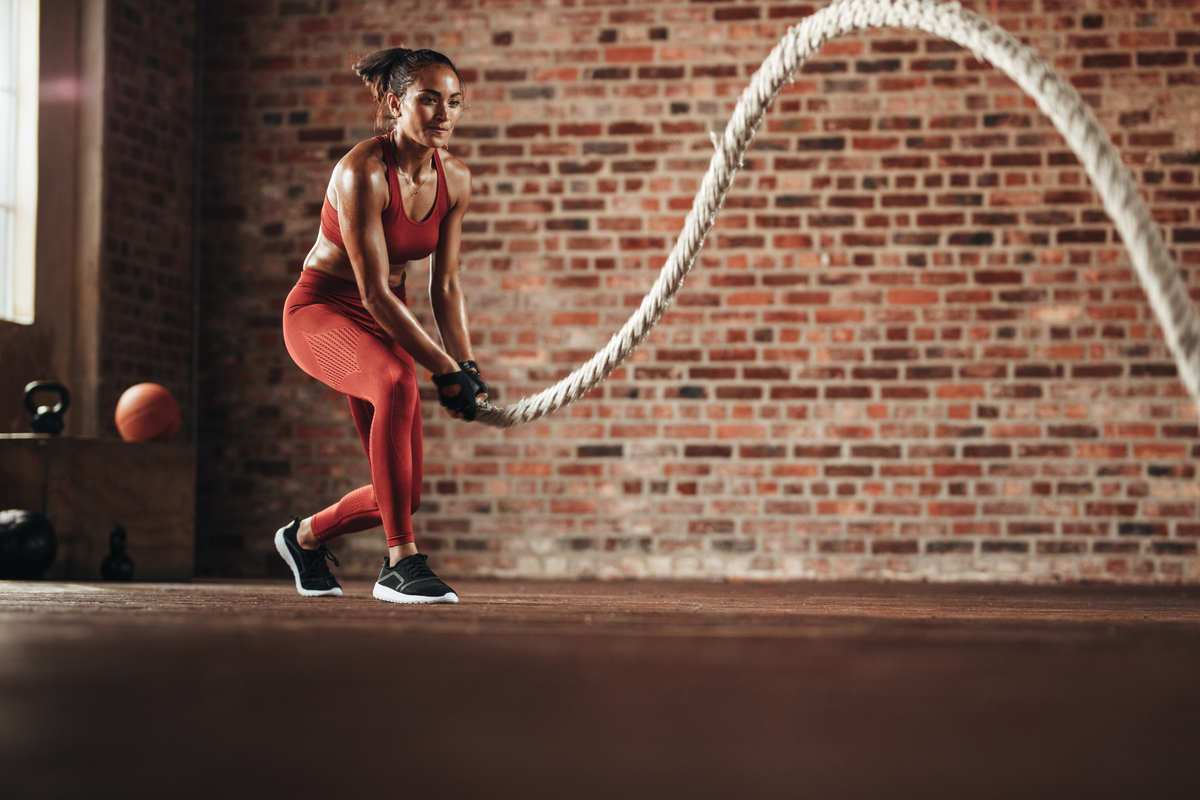 Woman using battle ropes at the gym