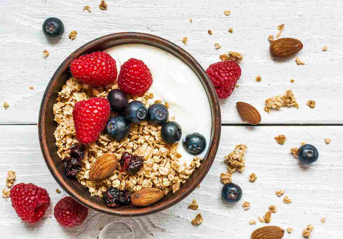overhead of bowl of oats, berries, nuts and Skyr Icelandic yoghurt