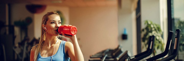 Woman drinking water in gym