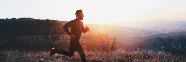 Man running at sunrise or sunset on heath