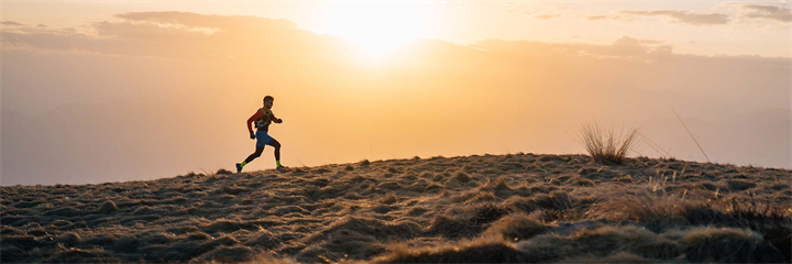 Man running in country side with sun rise in background