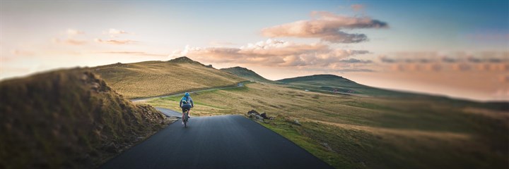 Person cycling through the hills